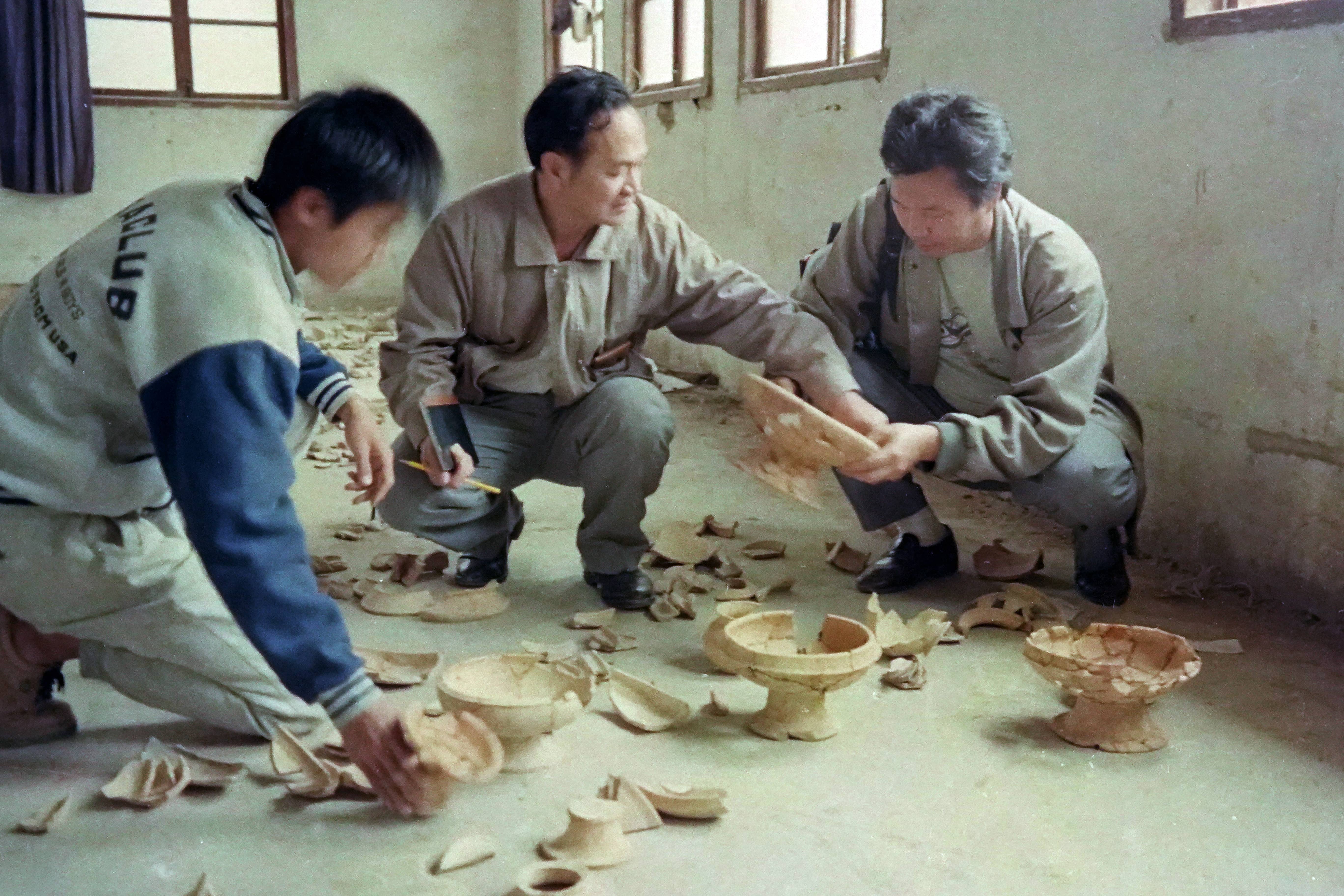 中大人类学系教授曾骐（中）与其学生三水博物馆馆员金爱群（左）分析研究出土陶器